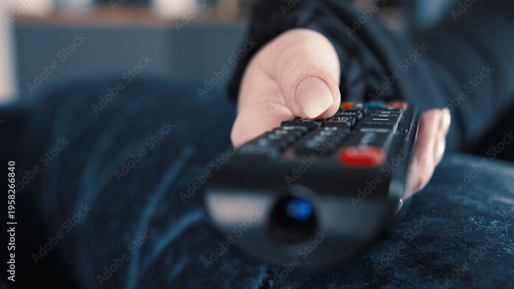 Fototapeta premium Person Holding TV Remote Control in Hand with Focus, have fun and enjoy