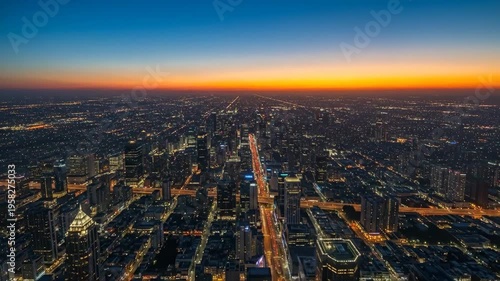Aerial of a city at sunset with a vibrant orange and blue sky