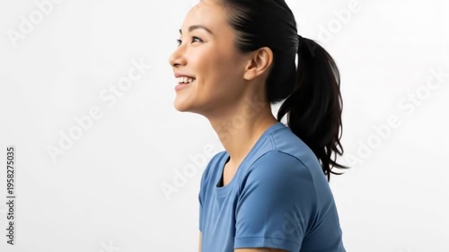 A smiling woman with a ponytail looking up in a blue shirt