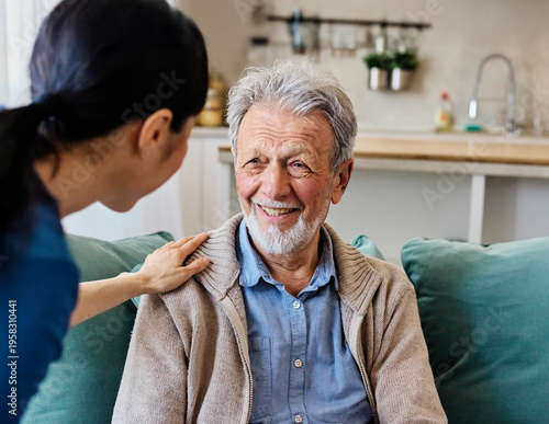 Doctor or nurse caregiver with senior man talking and having fun at home or nursing home