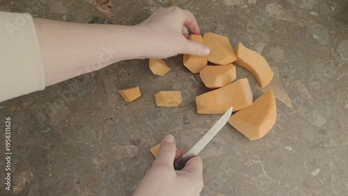female hands cut fresh raw pumpkin 