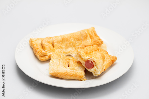 Freshly baked tasty sausage rolls on plate