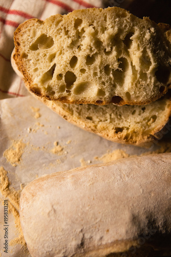 Close-up of sliced ciabatta bread revealing its airy porous crumb and crispy crust. Fresh homemade artisan bread, perfect texture for sandwiches and gourmet meals.