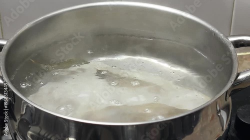 boiling cod fish in iron pot