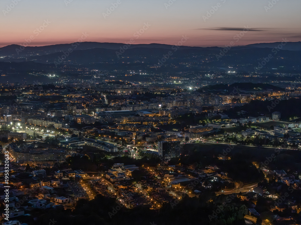 Fototapeta premium Cityscape of Braga at dusk with purple sky and glowing street lights, Portugal