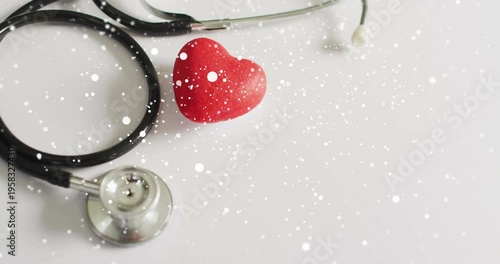 Fine white particles appearing around stethoscope and heart gradually filling scene to evoke health