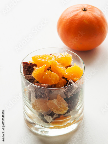 Glass with fresh oranges and chocolate cake dessert parfait, sweet snacks with fruits.