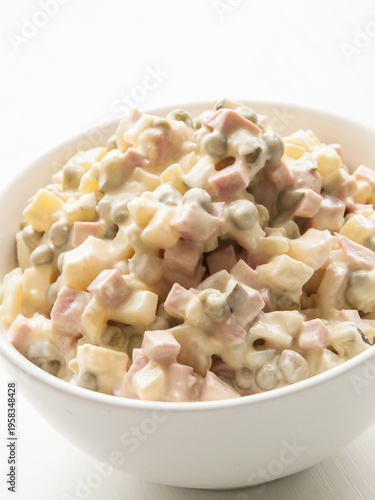 Bowl with traditional Olivier salad, classic dish made of veggies, meat covered in mayonnaise.
