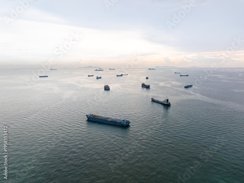 Fotografía Multiple Large Cargo Ships Anchored In A Calm Coastal Harbor At Twilight Represe