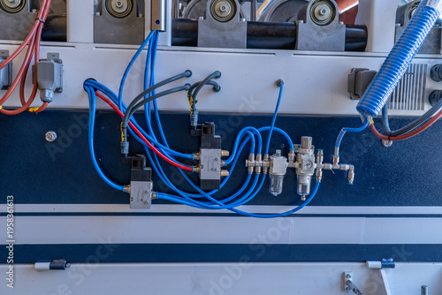 Pneumatic air preparation unit with spiral hose and cooling radiator on industrial machine.