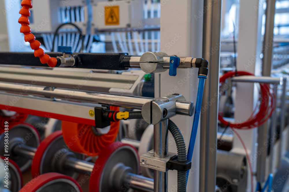 Fototapeta premium Automated production line conveyor system with rollers and pneumatic controls.