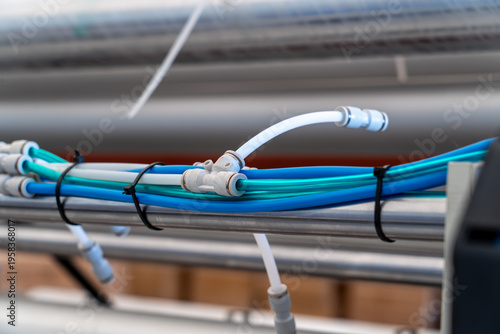 Close up of pneumatic push-in fittings and plastic hoses on industrial machinery