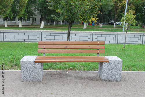 Wooden bench rests on gray stone bases