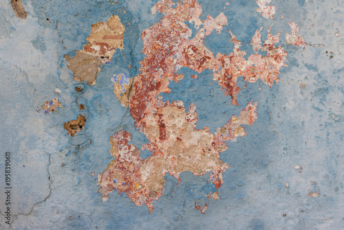 Fotografia Peeling blue paint revealing aged weathered wall texture