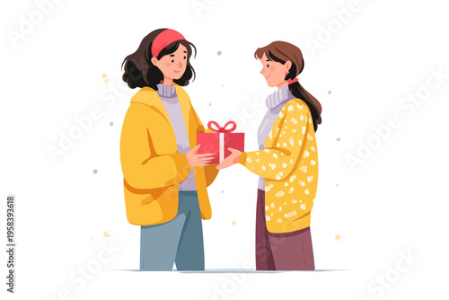 Two young females exchanging gift in winter attire