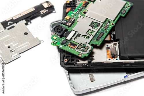 Smartphone repair process showing an opened device with parts removed and electronic components exposed on a table
