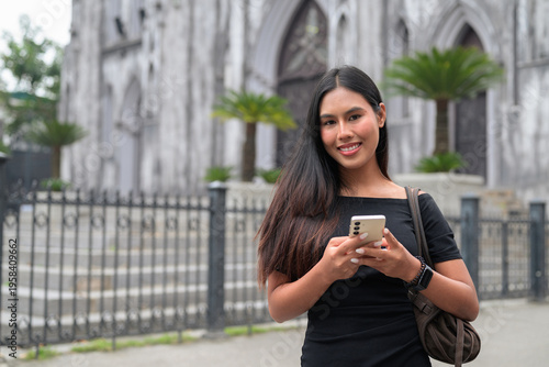 Thai Woman Using Smartphone at St Joseph's Cathedral Hanoi Vietnam