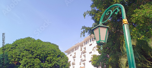 Antique street lamp with building and tree