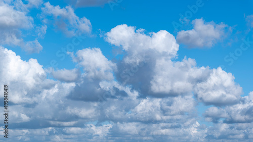 Billede på lærred Rows of cottony clouds drifted by the wind across the blue sky.