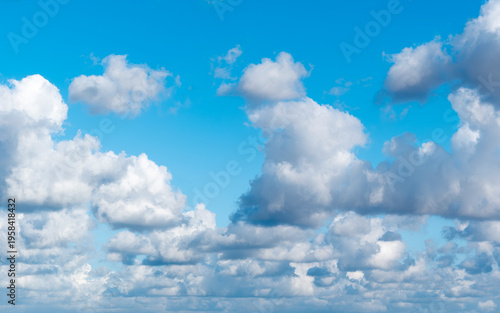 Foto Rows of cottony clouds drifted by the wind across the blue sky.