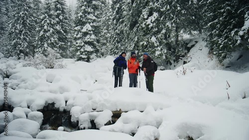 Three hikers posing for a photo in a snowy winter forest
