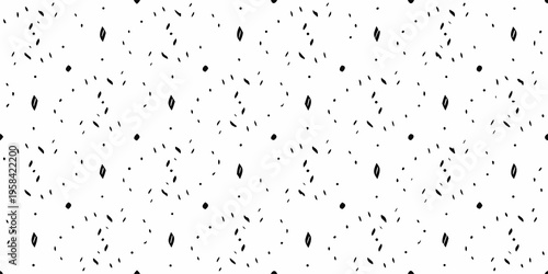 Abstract pattern of scattered small black shapes on a white background