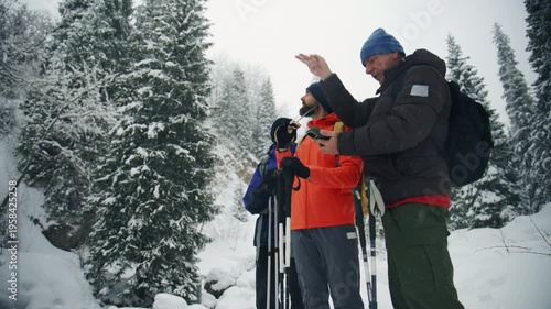 Friends hiking navigating with smartphone in snowy winter forest