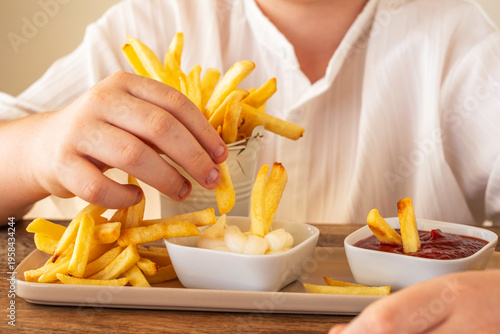 Food background with potato chips in the hands of a child.