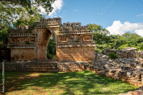Ancient stone archway stands tall amidst greenery