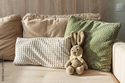 Konstfotografi Plush Bunny sitting on sofa. Cozy Easter Decoration