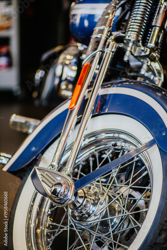 Obraz na plátně A detailed vertical macro shot focusing on the polished chrome front fork, wire-spoke rim, and classic whitewall tire of a blue vintage-style motorcycle