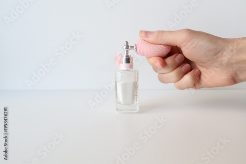 Photo taken in Poland, Krakow, March, a person holding a small perfume bottle with a pump, a glass jar with loose powder, decorative cosmetics, self-care for women,