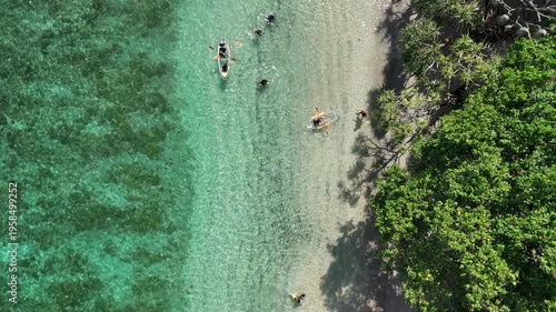 Aerial Bird's Eye View of Tourists Enjoying Clear Kayak and Swimming in Crystal Waters of Nipah Beach Lombok Indonesia