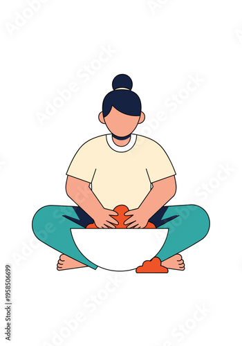 Person sitting cross legged kneading dough in a large white bowl
