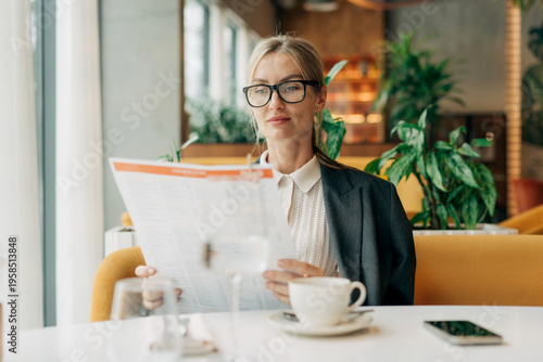 Billede på lærred Business Woman sits in a restaurant for lunch and reads the menu.