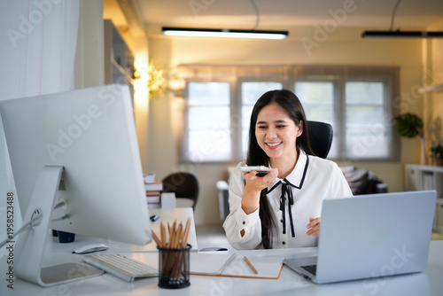 Bilde på lerret female work by laptop dictate audio message speech on mobile phone voice recording application