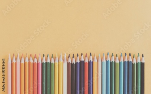 Colorful pencils arranged neatly on a plain background for art