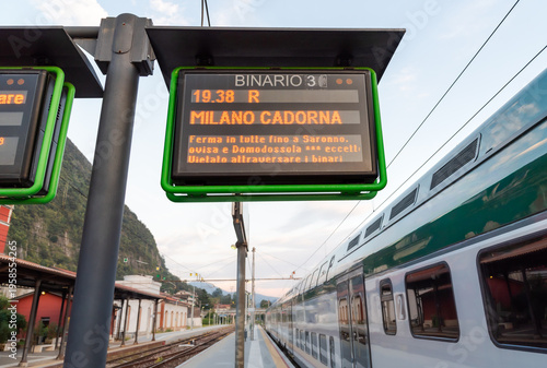 Wallpaper Mural Information panel displaying details of a departing train at Laveno Mombello railway station, Italy. Public transport schedule board showing train times and destinations. Torontodigital.ca