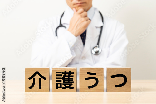 「介護うつ」と書かれたブロックと悩む医師