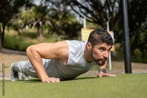 Photos Young man doing push-ups workout in park outdoors