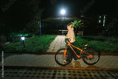 Foto Teen girl standing with bicycle at night, evening lifestyle, independence, mobility, active routine, urban neighborhood, adolescence, freedom and everyday life
