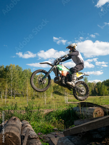 Konstfotografi Motocross rider jumping on motorcycle over log obstacle