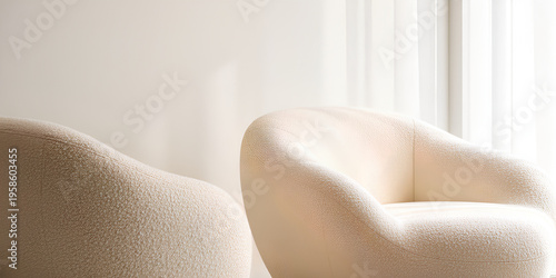 Two modern cream bouclé armchairs in a minimalist interior