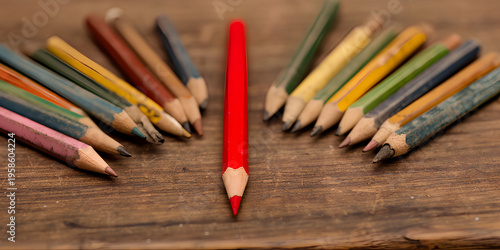 Prominent red pencil surrounded by fanned colored pencils