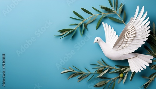 Top view of white paper dove decoration with olive tree branches on pale blue background with copy space
