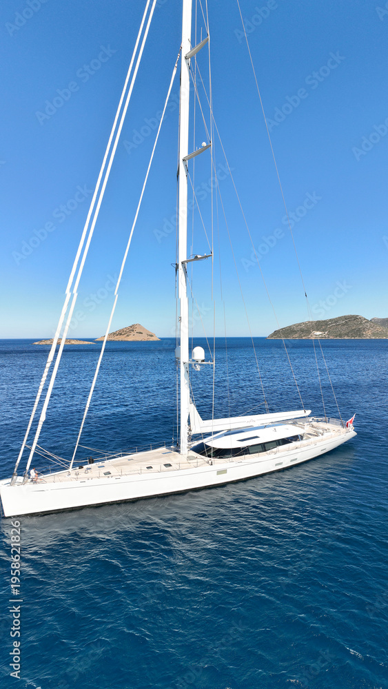 Fototapeta premium Aerial drone photo of beautiful sail boat anchored in deep blue Aegean Sea