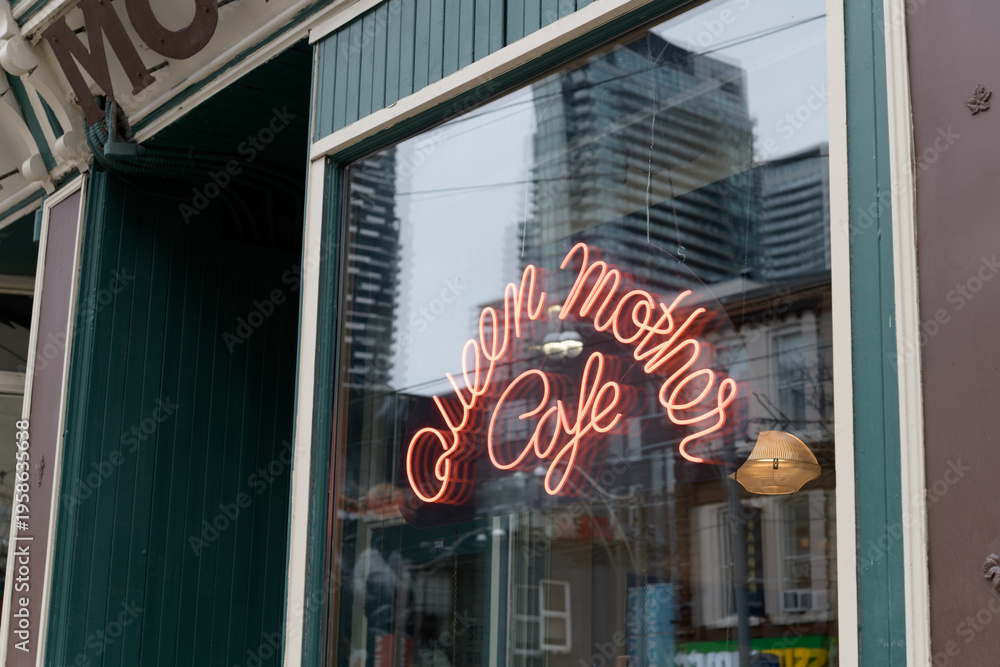 Fototapeta premium neon sign inside display window of Queen Mother Cafe, a restaurant, located at 208 Queen St W, Toronto