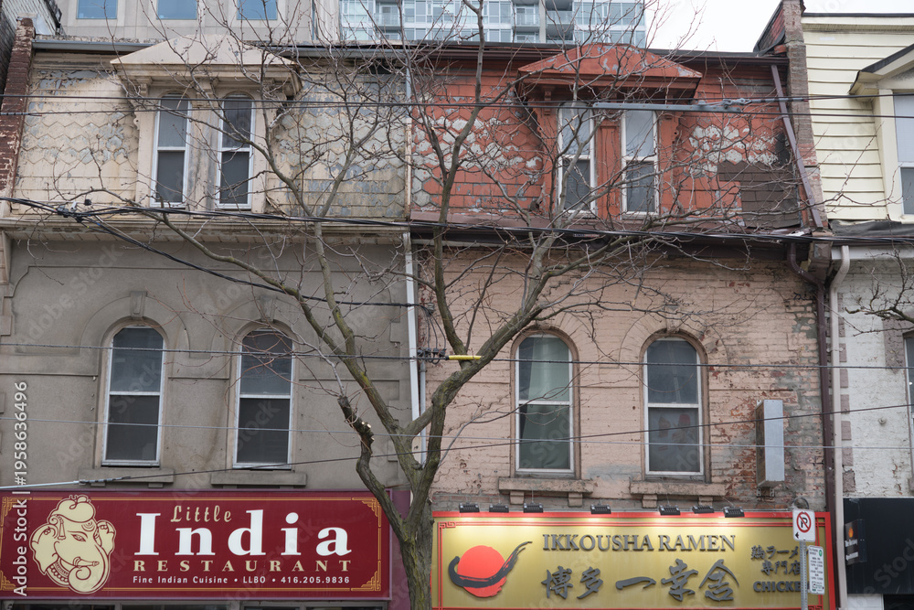 Fototapeta premium exterior building facade and sign of Little India Restaurant and Ikkousha Ramen on Queen St W, Toronto