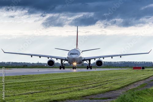 Front view of the big wide body passenger airplane taxiing at the airport taxiway