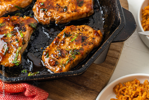 Honey bbq pork chops cooked in a cast-iron skillet. Meat dinner